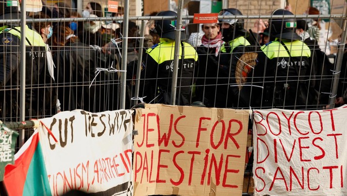 ISRAEL-PALESTINIANS/STUDENTS-PROTESTS Police officers stand next to pro-Palestinian protesters outside the University of Amsterdam during a protest against the ongoing conflict between Israel and the Palestinian Islamist group Hamas in Gaza, in Amsterdam, Netherlands, May 8 2024. REUTERS/Piroschka van de Wouw