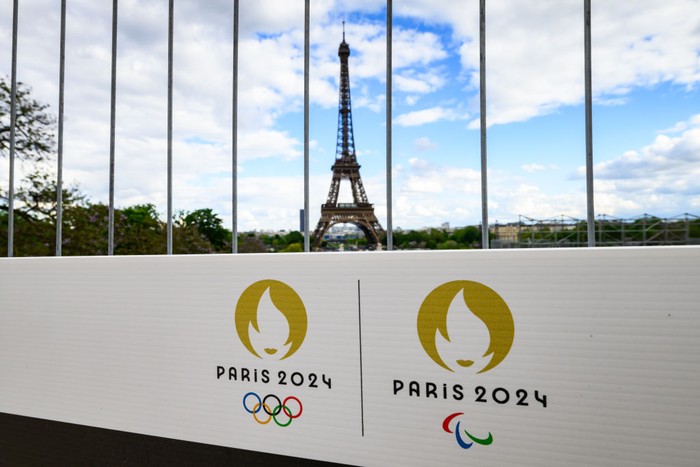 06 May 2024, France, Paris: The Olympic rings and the Paralympic Games logo can be seen on a sign on a construction fence in front of the Eiffel Tower. The Olympic Games and Paralympics take place in France this summer. Photo: Robert Michael/dpa (Photo by Robert Michael/picture alliance via Getty Images)