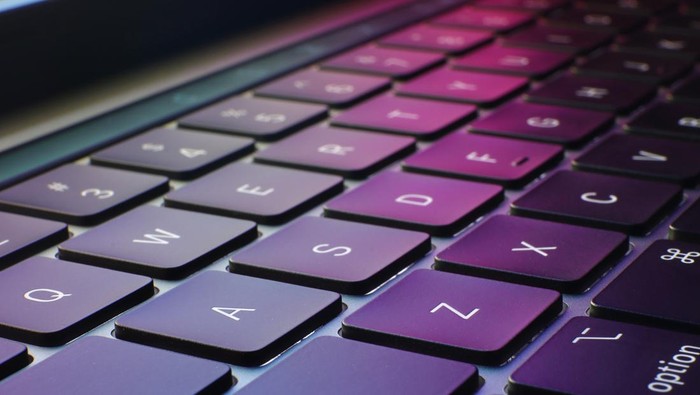closeup of keyboard with puple and colorful background, technology and information