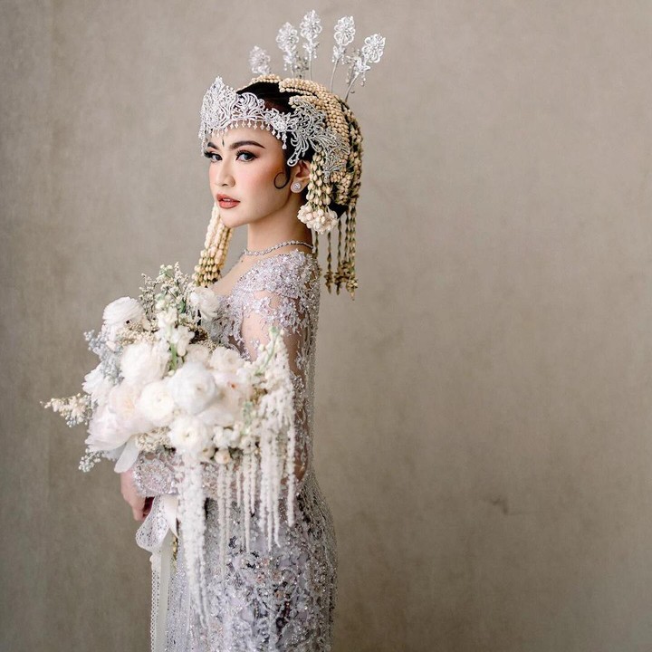 <p>Mahalini tampak cantik mengenakan kebaya Sunda berwarna putih dengan aksesoris kepala siger Sunda. Riasan Mahalini yang khas pengantin perempuan Sunda juga menambah kesan anggun. (Foto: Instagram @askyfebrianti)</p>