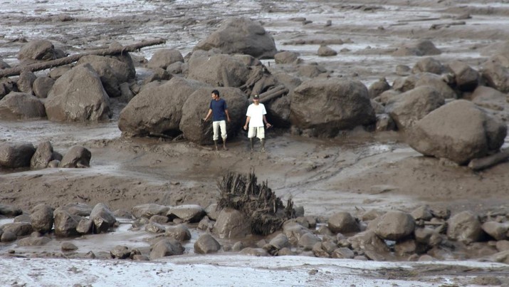 Masyarakat meninjau kawasan terdampak banjir bandang di Agam, Sumatera Barat, Indonesia, Minggu, (12/5/2024). (AP Photo/Ali Nayaka)