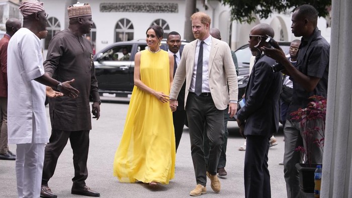 Prince Harry, left, and Meghan, right, holding hands upon arrival at the government house in Lagos Nigeria, Sunday, May 12, 2024. Prince Harry and his wife Meghan are in Nigeria to champion the Invictus Games, which Prince Harry founded to aid the rehabilitation of wounded and sick servicemembers and veterans. (AP Photo/Sunday Alamba)