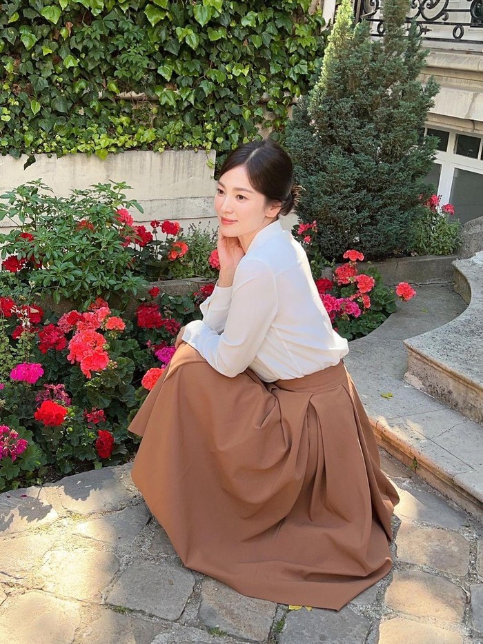 Padukan kemeja putih dengan rok dan aksesori untuk tampilan feminin/Foto: Instagram.com/kyo1122