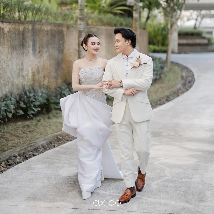<p>Rizky dan Mahalini tampil begitu serasi mengenakan pakaian bernuansa putih. Mahalini terlihat cantik memakai gaun rancangan Hian Tjen, sementara Rizky tampak memukai mengenakan setelan jas dari desainer Henri Winata. Foto: Instagram @rizkyfbian)</p>