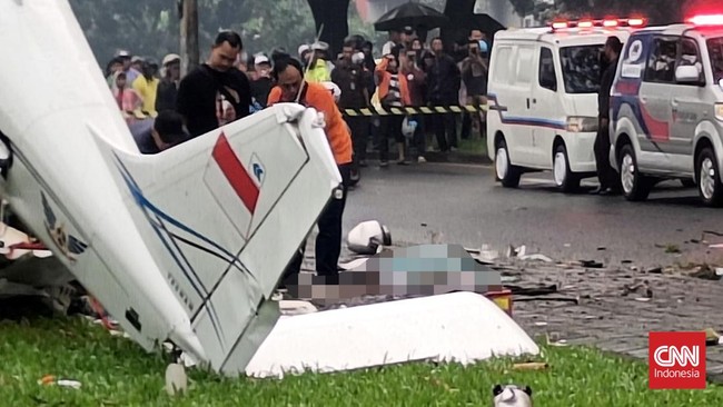 Seorang memandang pesawat nan jatuh di Lapangan Sun Burst, BSD City, Serpong, Tangerang Selatan, Minggu (19/5) sempat lenyap kendali dengan berputar-putar.