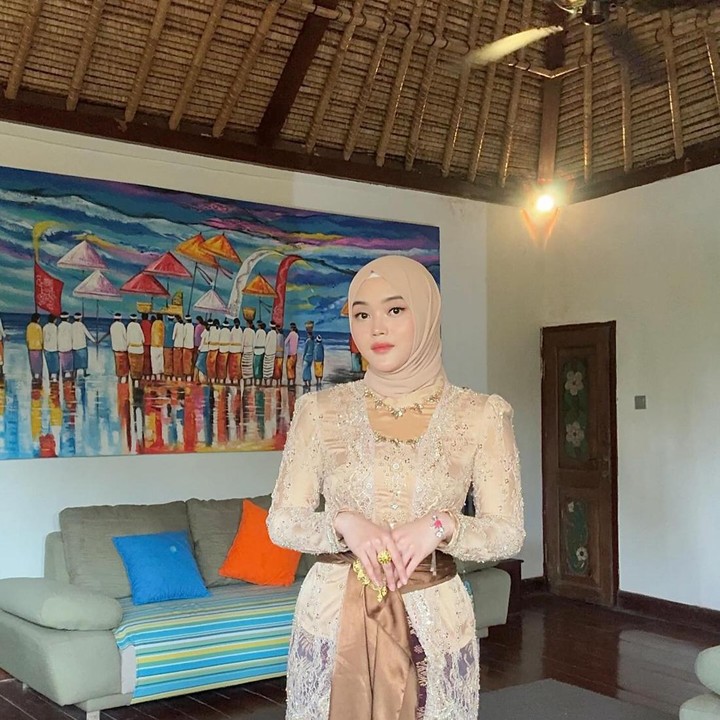 <p>Potret selanjutnya ketika Putri hadir di prosesi ala Bali dan Hindu, yakni Mepamit. Di momen ini, ia mengenakan kebaya Bali bernuansa cokelat berlengan panjang, dipadukan dengan batik khas Bali, lengkap dengan belt satin, hijab senada dandan make up yang membuat ia tambah menawan.(Foto: Instagram @putridelinaa)<br /><br /><br /></p>