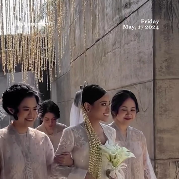 <p>Sasqia tampil cantik dalam balutan busana pengantin bernuansa putih. Diapit oleh dua orang di bagian sisi kanan dan kiri, ia berjalan perlahan sambil memegang buket bunga di dada. (Foto: Instagram @ale_aulia)<br /><br /></p>