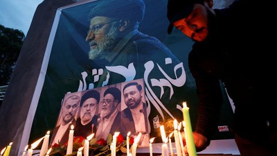 Seorang pria menyalakan lilin untuk menyampaikan belasungkawa atas kematian Presiden Iran Ebrahim Raisi dan lainnya, di luar kedutaan Iran, di Bagdad, Irak 20 Mei 2024. (REUTERS/Thaier Al-Sudani)