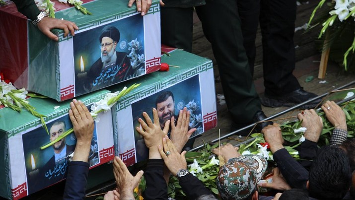 Warga Iran memberikan penghormatan terakhir saat jenazah mendiang Presiden Ebrahim Raisi diarak di jalana Tabr. (Ata Dadashi, Fars News Agency via AP)