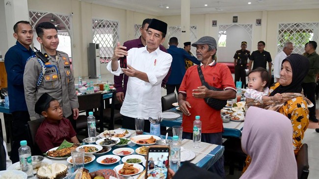 Jokowi membujuk penduduk beserta anak-anaknya untuk makan siang serta membagikan sembako kepada sejumlah penduduk di Kabupaten Kampar, Riau.