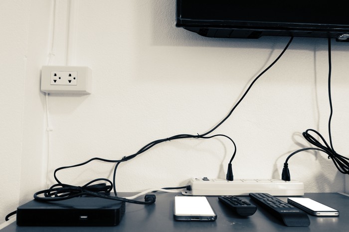 Electronic devices on the table under the TV such as smartphone,tv box,remote all in room