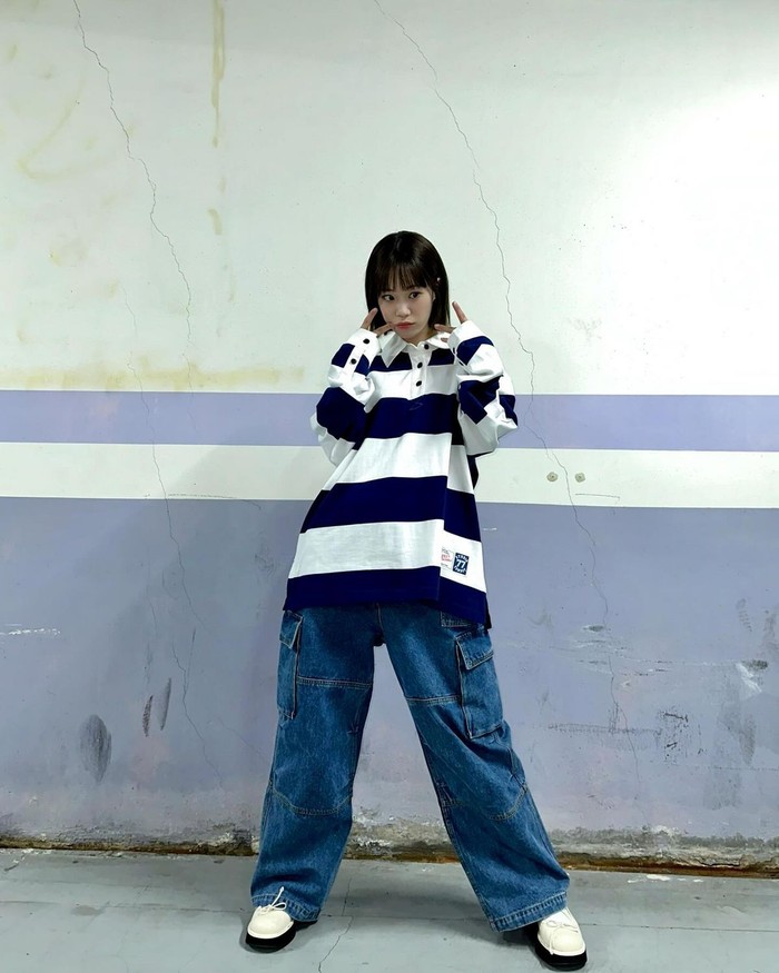 Gaya kaus rugby Heo Young Ji mengingatkan kita pada tren retro ala tahun 90-an. Ia memilih ukuran oversize dan memadukannya dengan celana denim siluet longgar untuk menonjolkan pinggulnya. / Foto: Elle Korea
