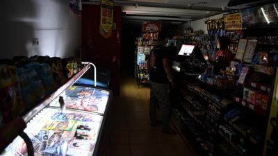 Pekerja melayani pembeli di sebuah minimarket yang menggunakan penerangan tambahan saat pemadaman listrik di Palembang, Sumatera Selatan, Selasa (4/6/2024). Jaringan listrik PLN di lima Provinsi yaitu