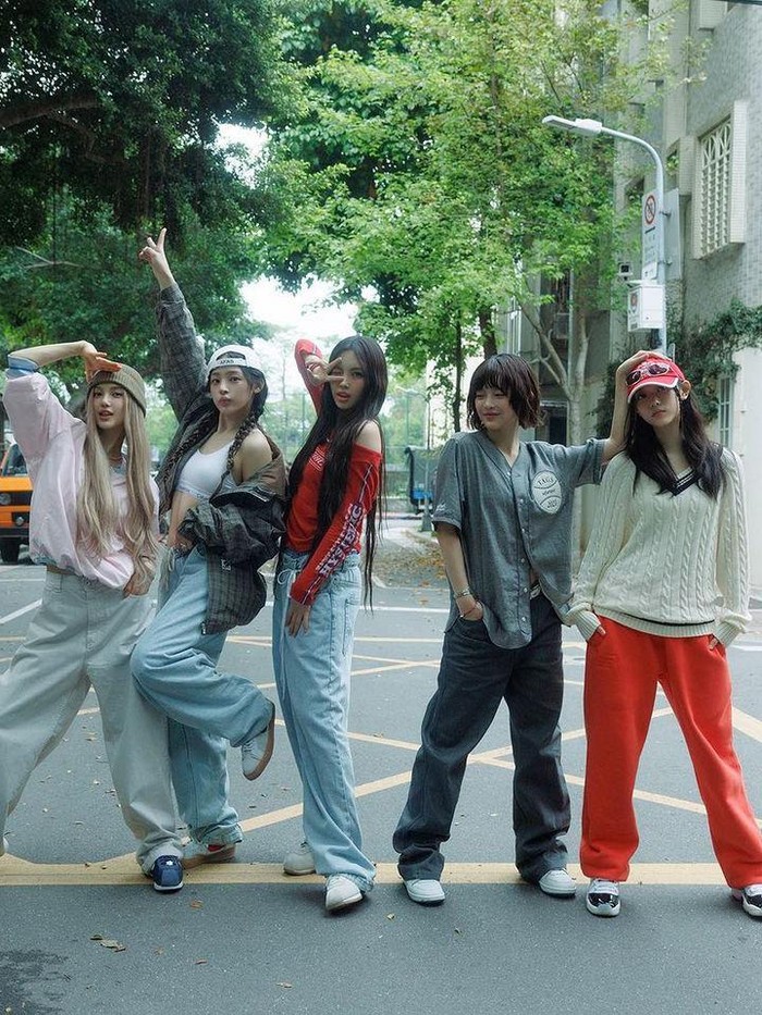 Fashion celana denim lebar yang ditampilkan dalam MV NewJeans ‘How Sweet’ menjadi elemen besar yang menunjukkan style yang unik. Para member memadukannya dengan atasan sporty, sepatu kets, dan aksesori yang meningkatkan kesan trendi./ Foto: Elle Korea