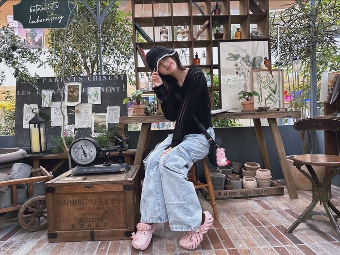 Gaeul IVE menambahkan topi rajut hitam dalam outfit-nya yang simple dengan kardigan hitam dan celana baggy jeans. Tampilannya tetap terlihat cute dengan sandal clog dan gantungan tas berwarna baby pink./ Foto: Instagram/fallingin__fall