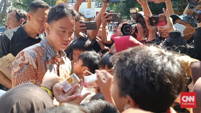 Setelah berkunjung ke rumah Khofifah, Gibran mampir ke sebuah SDN yang berjarak belasan meter dan membagi-bagi susu hingga buku ke siswa-siswi di sana.