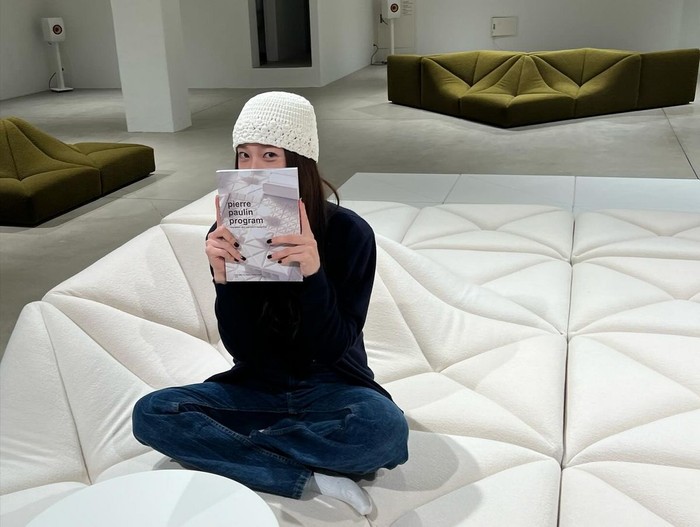 Krystal dengan stylish menambahkan item fashion topi rajut putih untuk menonjolkan tampilannya yang kasual dengan atasan hitam dan celana denim./ Foto: Elle Korea