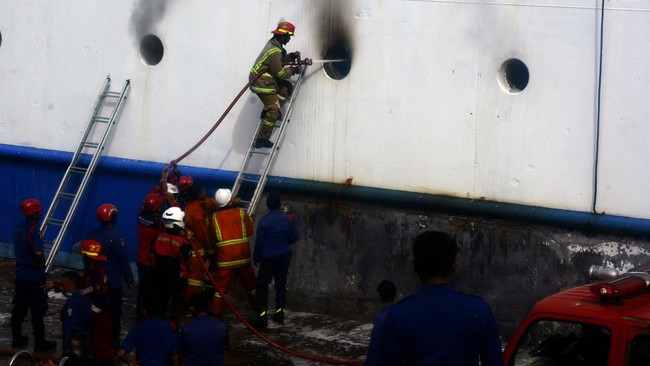 Ribuan penumpang panik dan berusaha turun dari kapal untuk menyelamatkan diri saat KM Usmini terbakar di Pelabuhan Makassar.