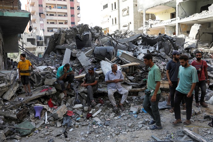 People walk among debris, aftermath of Israeli strikes at the area, where Israeli hostages were rescued on Saturday, as Palestinian death toll rises to 274, amid the Israel-Hamas conflict, in Nuseirat refugee camp in the central Gaza Strip, June 9, 2024. REUTERS/Abed Khaled