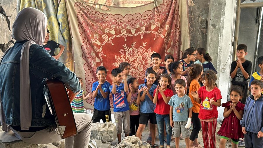 ISRAEL-PALESTINIANS/GAZA-MUSIC A Palestinian medical student, Rahaf Nasser plays music amid the ongoing conflict between Israel and Hamas, in Deir Al-Balah, in the central Gaza Strip June 5, 2024. REUTERS/Moaz Abu Taha