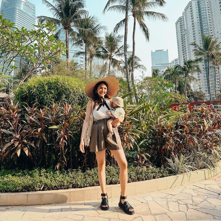 <p>Acha Sinaga selalu tampil <em>fashionable</em> baik di rumah maupun saat bepergian bersama kedua anaknya. Dalam sebuah unggahan, terlihat Acha menggendong si bungsu Keenan dengan celana kaos putih, celana pendek, dan topi yang lebar. "Suka banget <em>slide</em> 1 <em>outfit</em> anti gerah tapi kece," tutur seorang netizen. (Foto: Instagram: @achasinaga)</p>