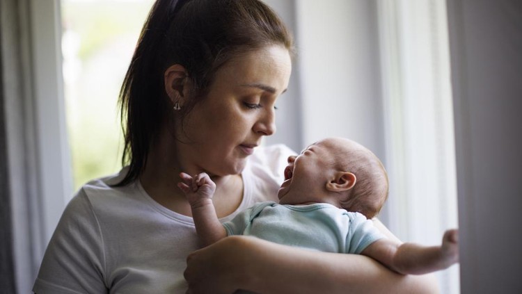 Newborn baby crying in mother's hands