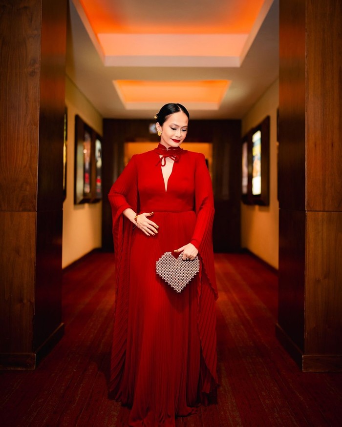 Ersa Mayori berbalutkan maxi dress dari Sebastian Red. Gaun kian memesona dengan aksen pleated cape serta pita pada garis leher/ Foto: Instagram.com/ersamayori/Imanuel Abraham