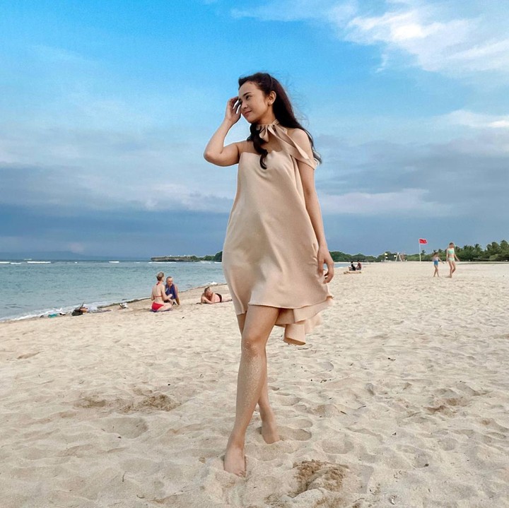 <p>Ketika bermain di pantai, Michelle memakai <em>beach wear</em> berupa <em>sleeveless dress</em> yang memiliki aksen pita pada leher. (Foto: Instagram @michelleziu)</p>