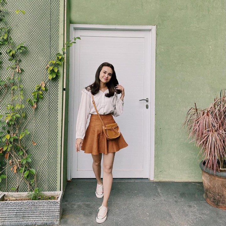 <p>Michelle Ziudith tampil feminin dengan<em> loose shirt</em> yang dipadukan bersama<em> mini flare skirt.</em> Ia menyempurnakan penampilannya dengan <em>sling bag</em> dan <em>sneakers.</em> (Foto: Instagram @michelleziu)</p>