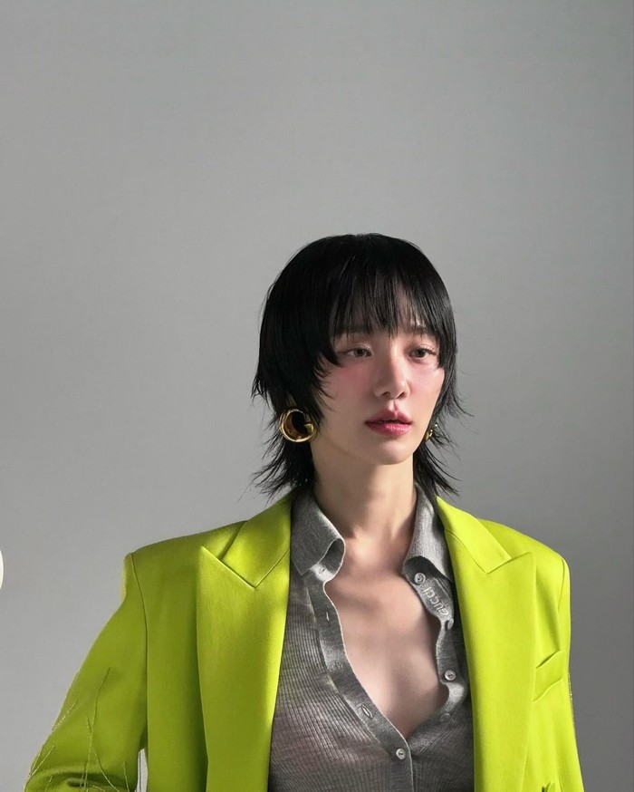 Park Gyu Young memancarkan aura chic dengan gaya rambut dan anting-anting yang berani. Ia memamerkan pesona sensualnya dengan mengenakan outer berwarna hijau neon dengan kaus rajut yang santai. / Foto: Elle Korea