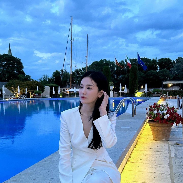 <p>Outfit Song Hye Kyo yang terakhir masih bertema all-white yang dapat menampilkan aura glamor serta karismatik. Outfit ini bisa dipadukan dengan tote bag dari berbagai warna untuk memberikan fashion point. (Foto: Instagram @kyo1122)</p>
