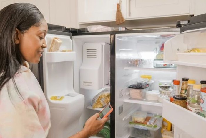 Ilustrasi perempuan berdiri di depan kulkas/Foto: Pexels/Kindel Media