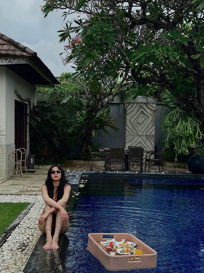 Dengan menggunakan bikini serta kacamata hitam, Nana terlihat sangat eksotis berada di pinggir kolam renang. Dalam caption, ia berada di Azura Beach Restaurant, yakni salah satu resort mewah di Jimbaran, Bali./ Foto: instagram.com/jin_a_nana