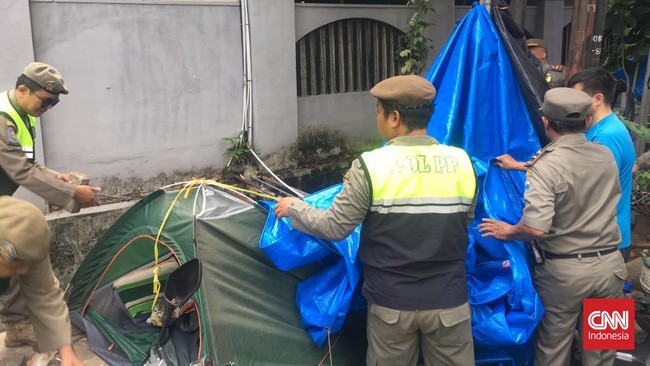 Petugas Satpol PP menertibkan para pencari suaka yang mendirikan tenda di depan Kantor UNHCR di Setiabudi, Jakarta Selatan, Selasa (2/7) pagi.