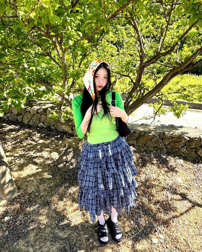 Joy memamerkan style rok lipit 3D bermotif kotak-kotak yang unik. Seolah menangkap suasana musim panas yang menyegarkan, rok tersebut dipadukan dengan kaus berwarna hijau cerah yang penuh kesegaran bak peri hutan. / Foto: Elle Korea