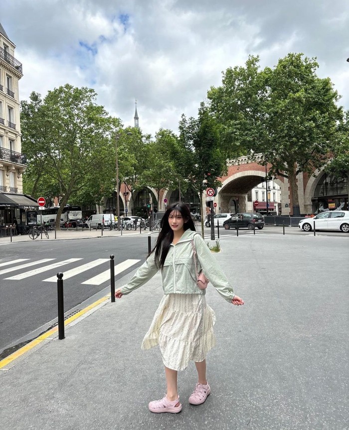 Leeseo tampil cheerful khas musim panas dengan memadukan jaket hoodie dan rok lipit bermotif bunga-bunga. Ia menambah tas mini dan sepatu berwarna pink yang membuat tampilannya lebih manis dan menarik. / Foto: Instagram/eeseooes