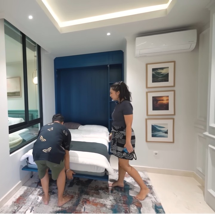 <p>Apartemen itu juga dilengkapi dengan ruang serbaguna yang memiliki kasur lipat. Kasur tersebut dapat disembunyikan menjadi lemari jika tidak sedang digunakan. "Jadi kasurnya bisa kita tutup ke atas. Kalau ditutup bisa clean area, bisa dijadiin <em>playroom</em> buat anak-anak. Multifungsi sekali ruangan ini," papar Tipang. (Foto: YouTube Arief Muhammad)</p>