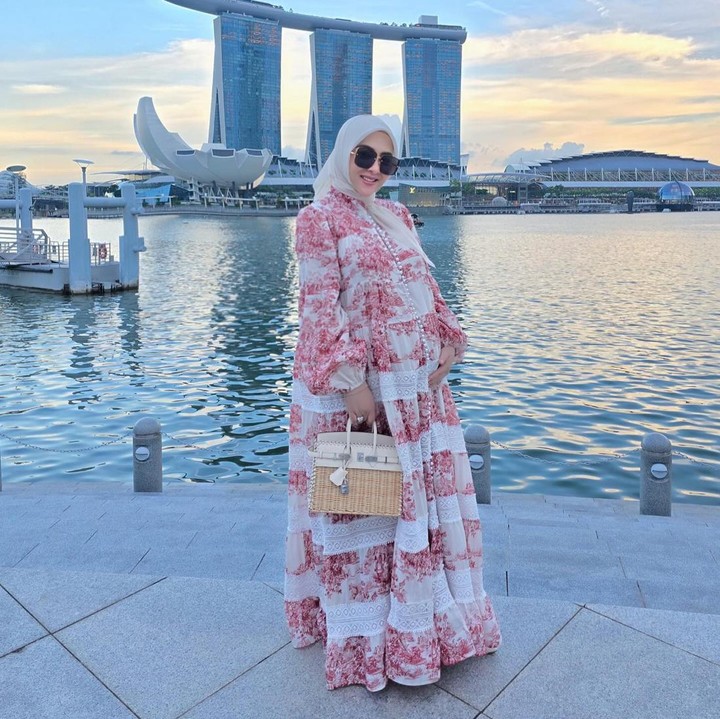 <p>Tampil lebih elegan, Syahrini mengenakan dress bermotif <em>floral</em> dengan paduan warna putih dan merah muda. Penampilannya semakin lembut dengan hijab segi empat warna putih gading. (Foto: Instagram @princessyahrini)</p>