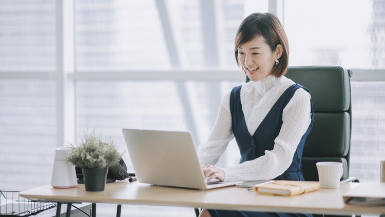 asian chinese beautiful female manager working using her laptop typing in the office