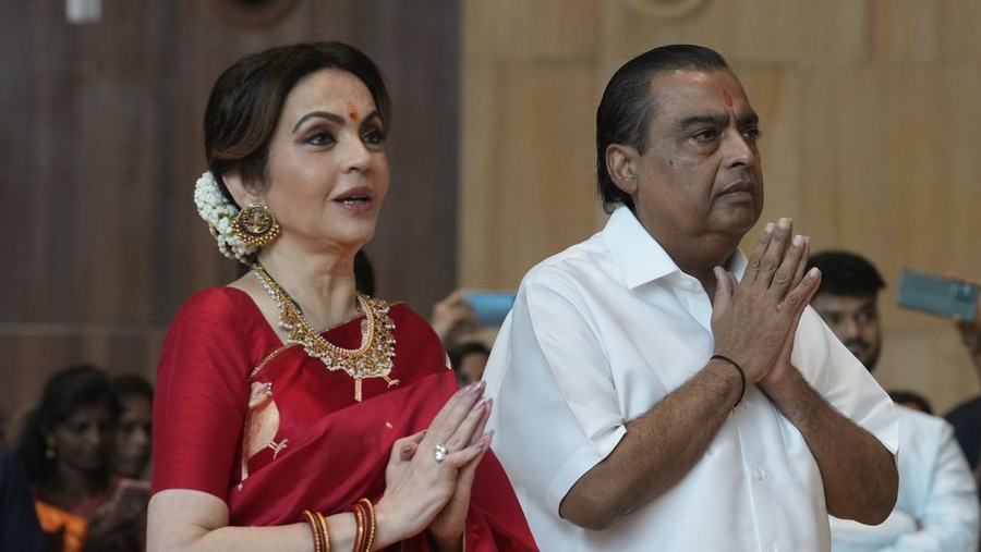 Chairman of Reliance Industries Limited Mukesh Ambani, third from left, poses for a photograph with his family members and underprivileged couples during a mass wedding organized by him as the part of pre-wedding celebrations of his youngest son, Anant Ambani, in Navi Mumbai, India, Tuesday, July 2, 2024. (AP Photo/Rafiq Maqbool)