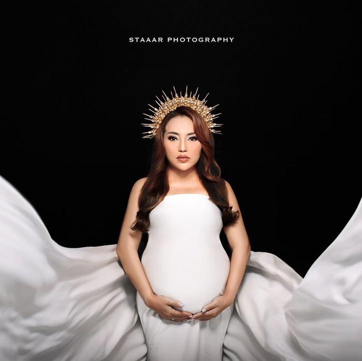<p>Dalam maternity shoot ini, Mpok Alpa terlihat anggun mengenakan gaun berwarna putih dengan aksesoris mahkota emas. Mpok Alpa tampak cantik bak seorang Dewi. (Foto: Instagram @nina_mpokalpa)</p>