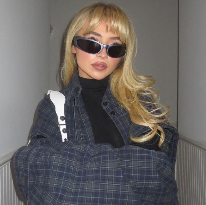 <p><em>Outfit boyish</em> yang pernah dipakai Sabrina Carpenter adalah paduan simpel kemeja dan inner. Artis kelahiran 1999 ini memadukan kemeja kotak dongker dengan <em>neck sleeve hitam</em>, tak lupa dengan kacamata yang eksentrik. (Foto: Instagram @sabrinacarpenter)</p>