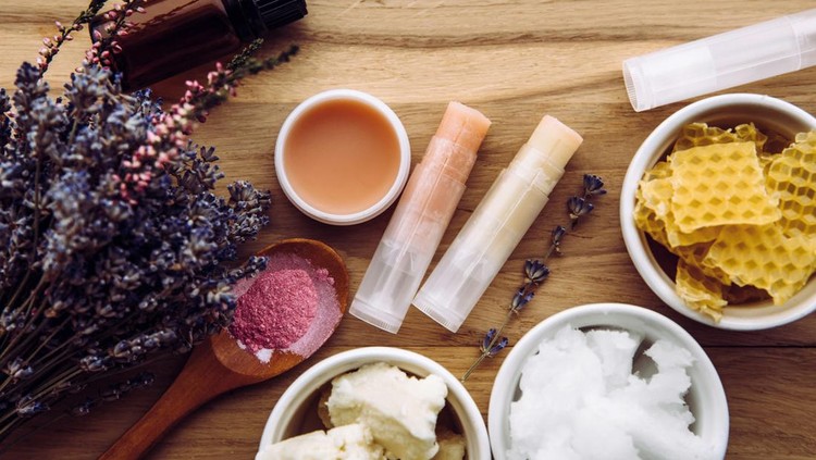 ilustrasi lip care, lip balm, lip mask Ingredients for homemade lip balm: shea butter, essential oil, mineral color powder, beeswax, coconut oil. Homemade lip balm lipstick mixture with ingredients scattered around.