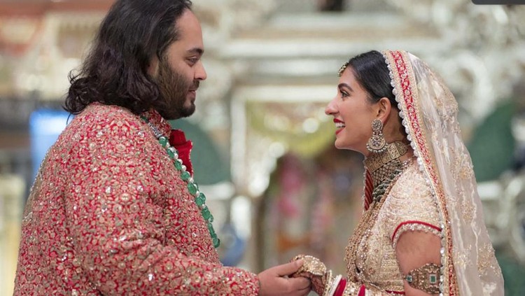 Anant Ambani, kiri, putra miliarder Mukesh Ambani, berpegangan tangan dengan Radhika Merchant saat upacara pernikahan mereka di Jio World Convention Center di Mumbai, India, Jumat, 12 Juli 2024.