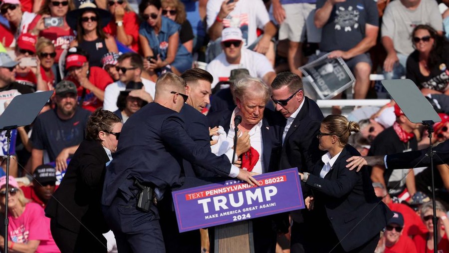 Republican presidential candidate and former U.S. President Donald Trump is assisted by the Secret Service after gunfire rang out during a campaign rally at the Butler Farm Show in Butler, Pennsylvania, U.S., July 13, 2024. REUTERS/Brendan McDermid