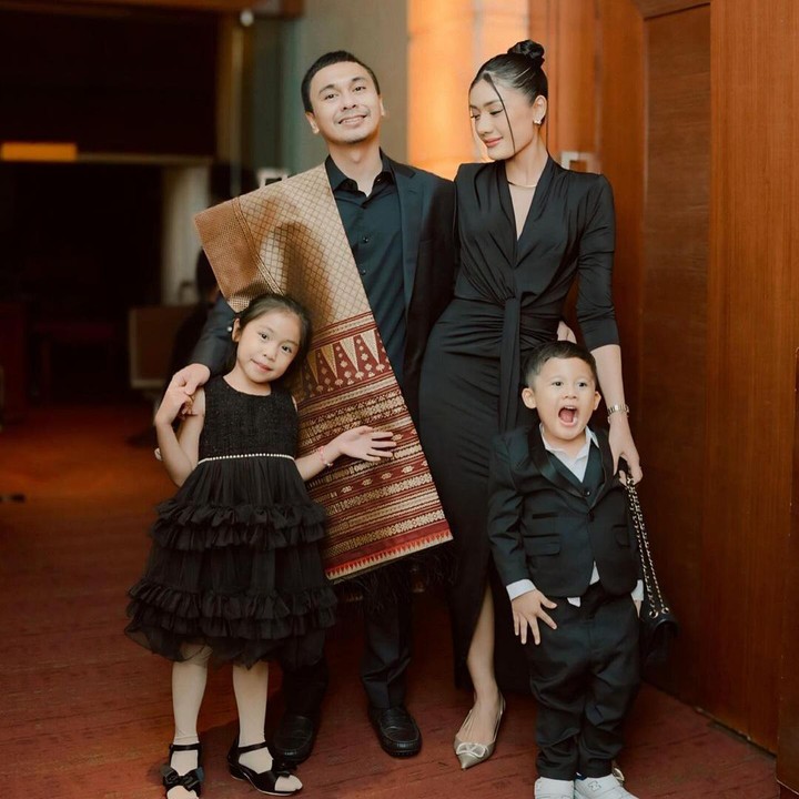 <p>Anisaa bersama Raditya Dika dan kedua anak mereka kompak mengenakan pakaian bernuansa warna hitam, Bunda. Alenia dan Anissa mengenakan gaun hitam, sementara Raditya Dika dan putranya Aksara Asa mengenakan setelan jas hitam. Raditya Dika sendiri tampak menggunakan kain ulos Batak sebagai aksesoris. (Foto: Instagram @anissaaziza)</p>