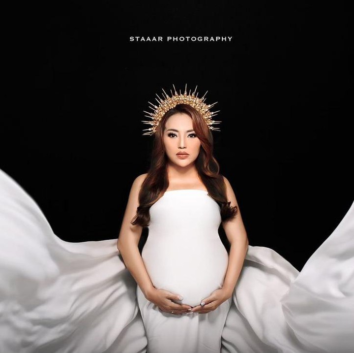 <p>Dalam maternity shoot kali ini, Mpok Alpa mengenakan dua gaun. Selain gaun biru muda, ia juga memakai gaun anggun berwarna putih. Penampilannya kali ini juga bak peri. (Foto: Instagram @nina_mpokalpa)</p>