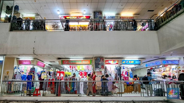 Penjual sepatu merapihkan dagangannya sebelum menutup toko di Blok A asar Tanah Abang, Jakarta, Kamis (18/7/2024). Sejumah pedagang Blok A Pasar Tanah Abang khususnya di lantai 3  Blok A mengaku tengah dilanda kepanikan karena khawtir akan adanya razia barang impor. (CNBC Indonesia/Faisal Rahman)