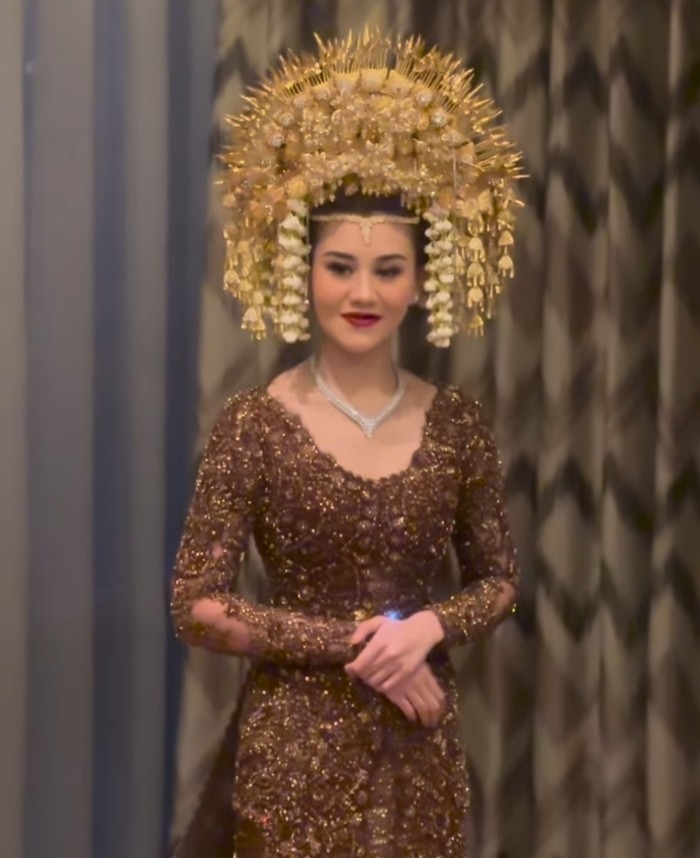 Kebaya coklat yang dipakai oleh Aaliyah di acara resepsi berhias payet dan bordir. Kesan elegan semakin terpancar saat dipadukan dengan kalung. (Aaliyah Massaid/Foto:instagram.com/studioboh)