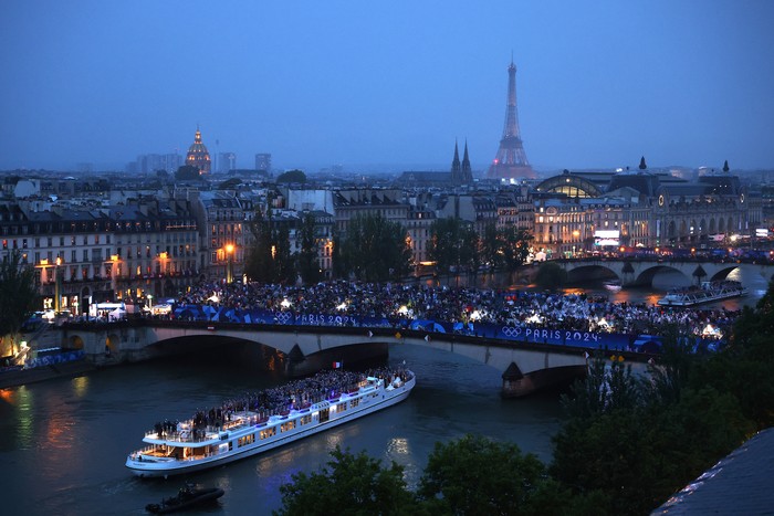 PARIS, FRANCE - JULY 26: Spectators look on as athletes from Team France pass by on a boat on the River Seine during the opening ceremony of the Olympic Games Paris 2024 on July 26, 2024 in Paris, France. (Photo by Richard Heathcote/Getty Images)